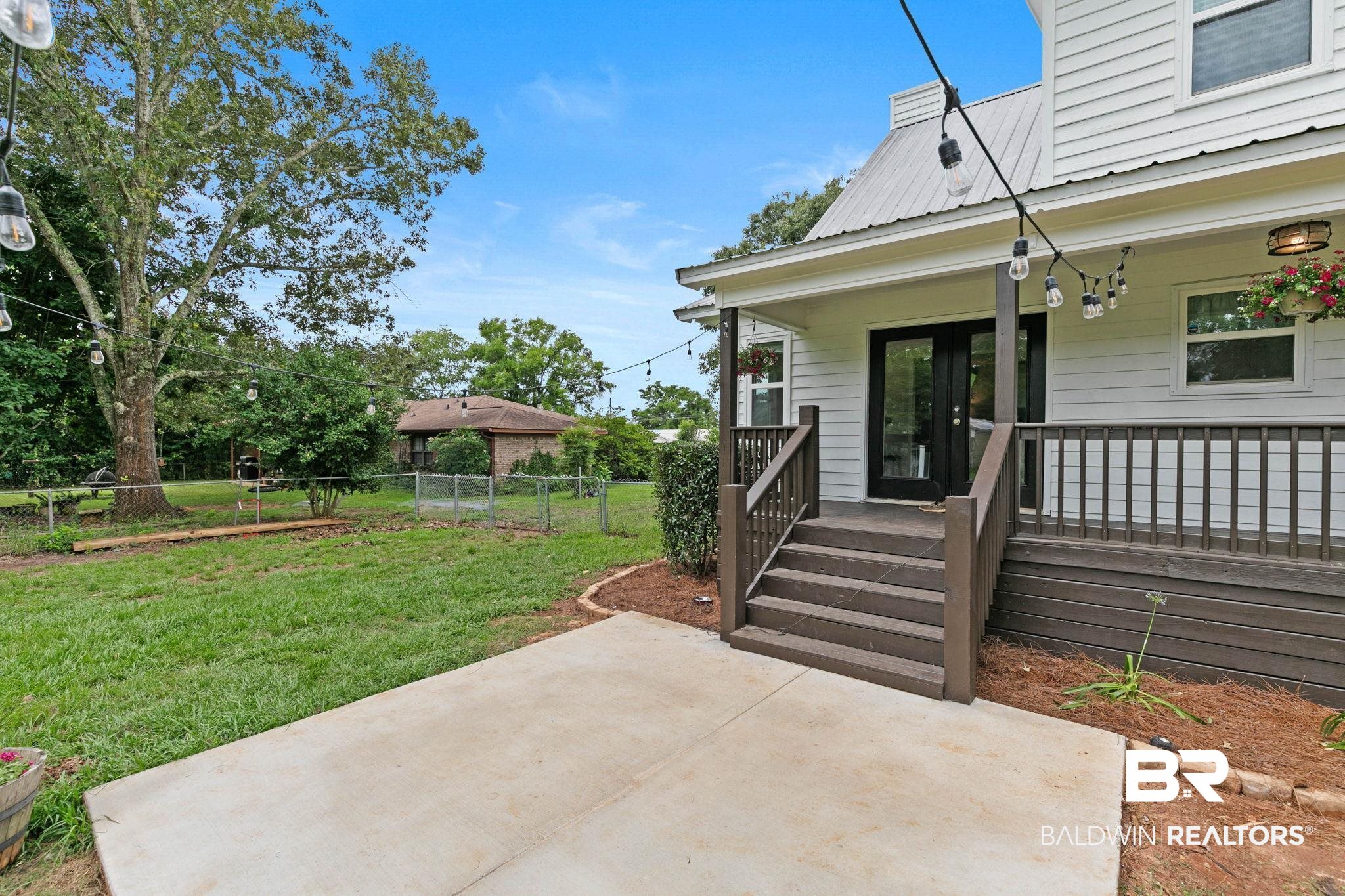 22810 High Ridge Road Fairhope, AL 36532 - Photo 59 of 78 Rear exterior featuring a spacious concrete patio, multi-level wood deck with railings, and full-light double doors
