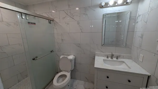 a bathroom with a sink toilet and shower