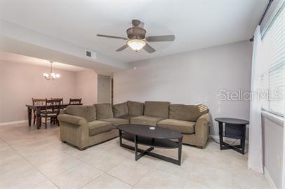 2360 Southwest Archer Road, Unit 506 Gainesville, FL 32608 - Photo 2 of 9 a living room with furniture and a chandelier