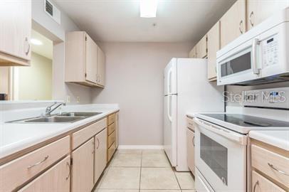 2360 Southwest Archer Road, Unit 506 Gainesville, FL 32608 - Photo 5 of 9 a kitchen with stainless steel appliances granite countertop a sink and a stove top oven