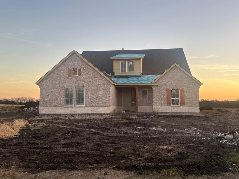 View of front facade featuring brick siding and covered porch