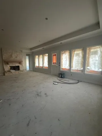 en empty room with windows and ceiling fan