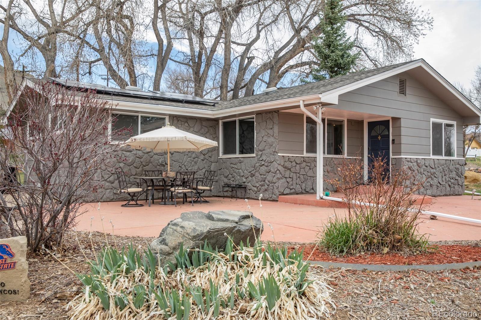 a front view of a house with a yard and potted plants