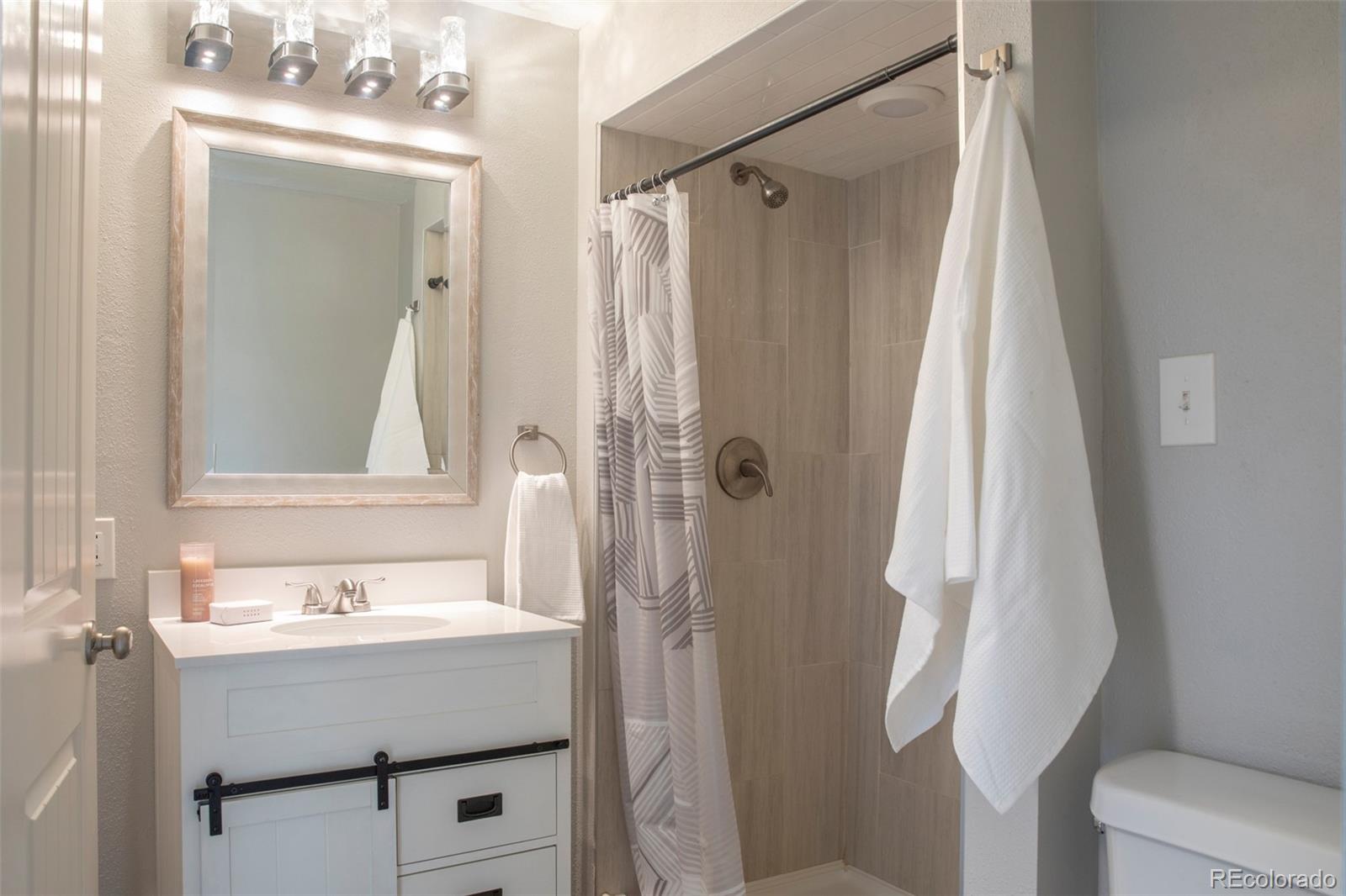 5380 Easley Road Golden, CO 80403 - Photo 23 of 38 a bathroom with a sink a mirror a toilet and shower