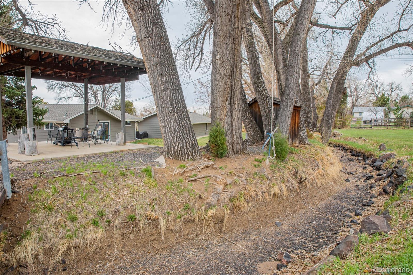 5380 Easley Road Golden, CO 80403 - Photo 28 of 38 a backyard of a house with lots of green space and fountain