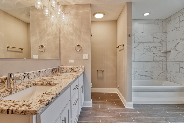 747 Arlington Road Riverside, IL 60546 - Photo 12 of 16 a bathroom with a granite countertop sink a mirror and a bathtub