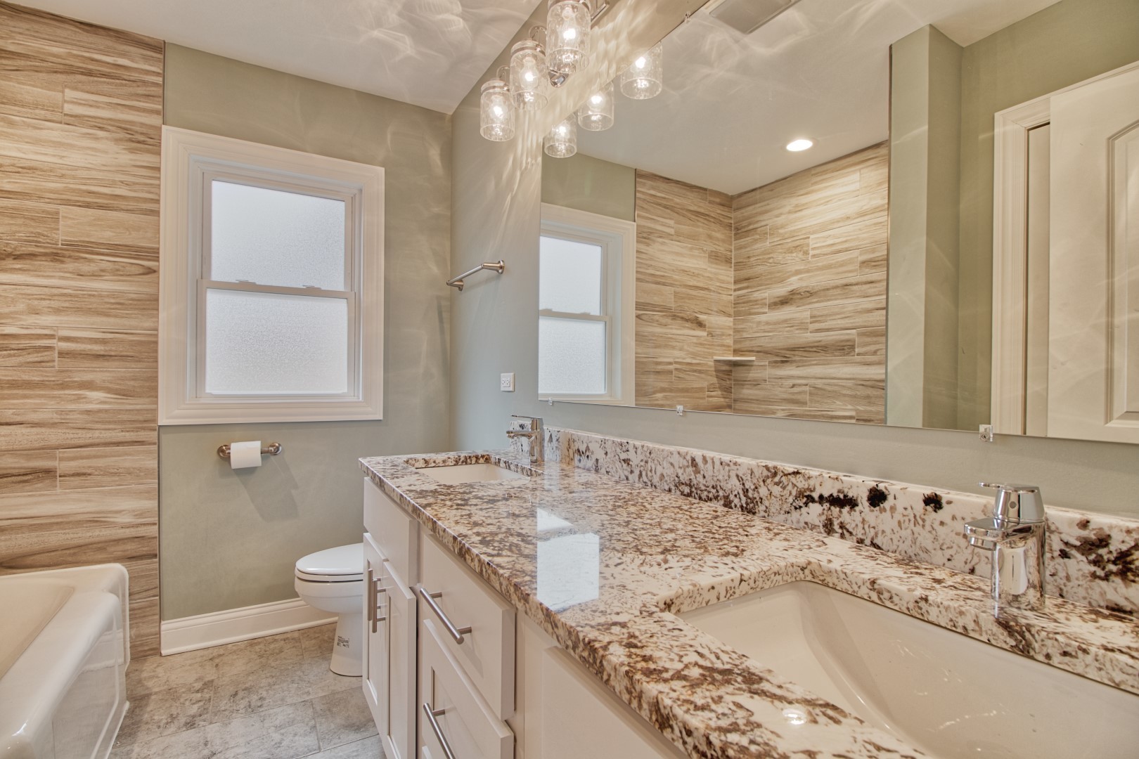 747 Arlington Road Riverside, IL 60546 - Photo 7 of 16 a bathroom with a granite countertop sink a large mirror and a bathtub