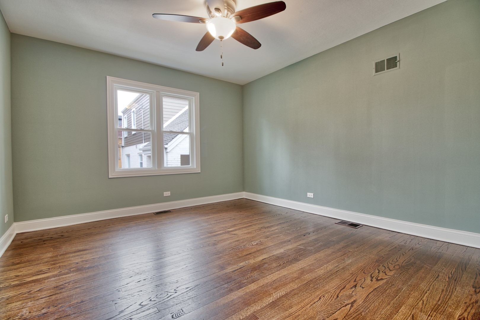 747 Arlington Road Riverside, IL 60546 - Photo 8 of 16 an empty room with wooden floor chandelier fan and windows