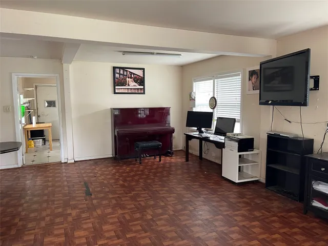 a living room with furniture a flat screen tv and kitchen view