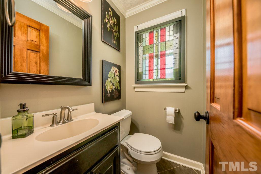 6108 Wolverhampton Drive Raleigh, NC 27603 - Photo 16 of 30 a bathroom with a sink a toilet and a window