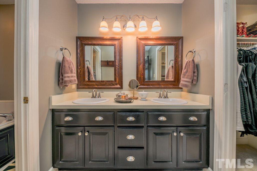 6108 Wolverhampton Drive Raleigh, NC 27603 - Photo 22 of 30 a bathroom with a double vanity sink and a mirror