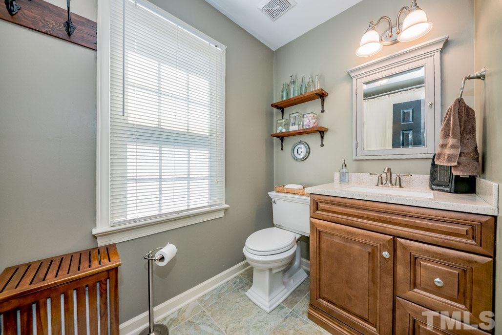 6108 Wolverhampton Drive Raleigh, NC 27603 - Photo 24 of 30 a bathroom with a sink a toilet and a mirror