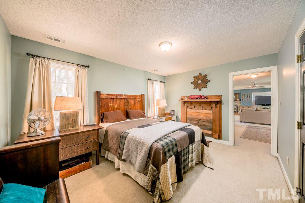 6108 Wolverhampton Drive Raleigh, NC 27603 - Photo 28 of 30 a bedroom with a bed and wooden floor