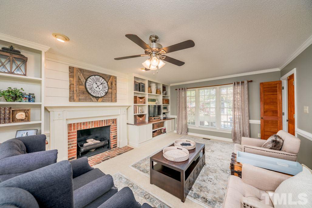 6108 Wolverhampton Drive Raleigh, NC 27603 - Photo 9 of 30 a living room with furniture a fireplace and a large window