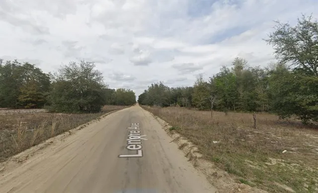 a view of a street with a yard in back