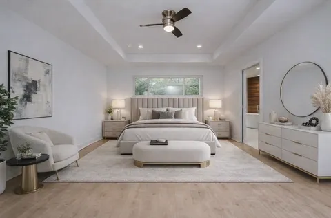 a bedroom with a bed a mirror and lamp