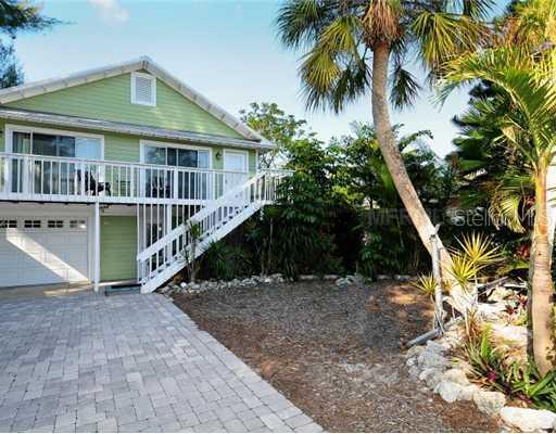 a front view of a house with a yard and potted plants