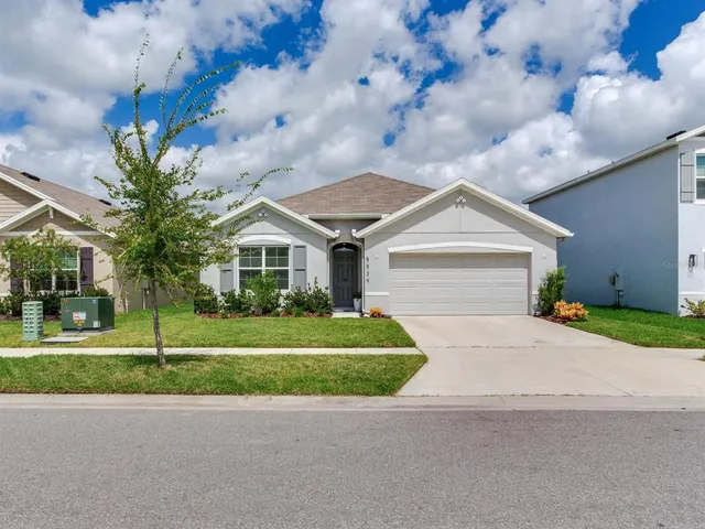 a front view of a house with a yard and garage