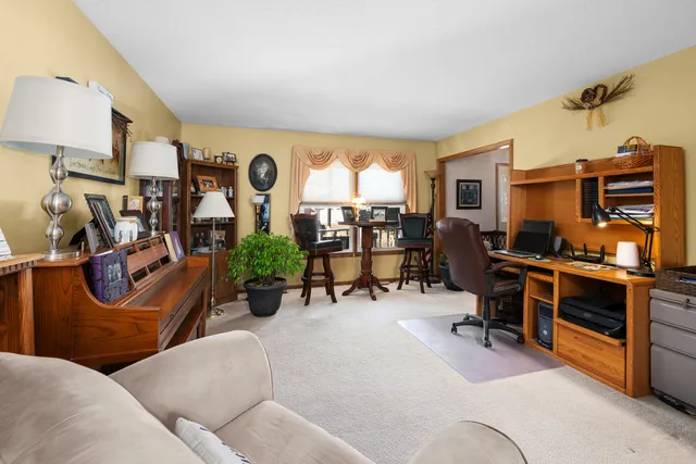 a living room with furniture piano and a chandelier