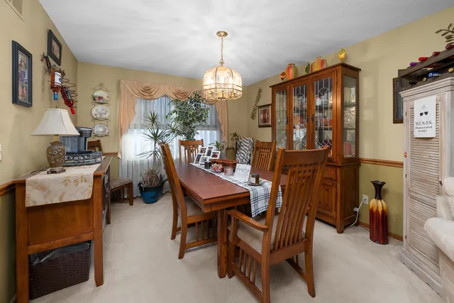 a dining room with furniture a chandelier and wooden floor