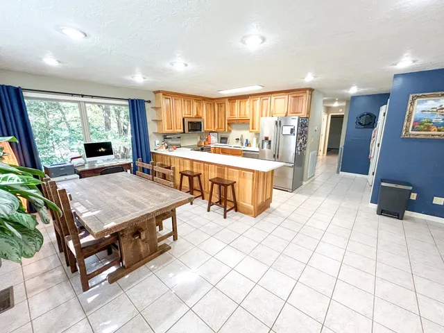 a living room with stainless steel appliances kitchen island granite countertop a large kitchen counter top a stove and a sink with living room