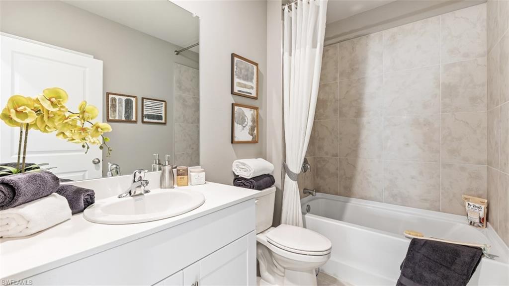 17752 Shade Tree Loop Punta Gorda, FL 33982 - Photo 11 of 40 Model Photo -Full bath with vanity and shower / bath combination with curtain