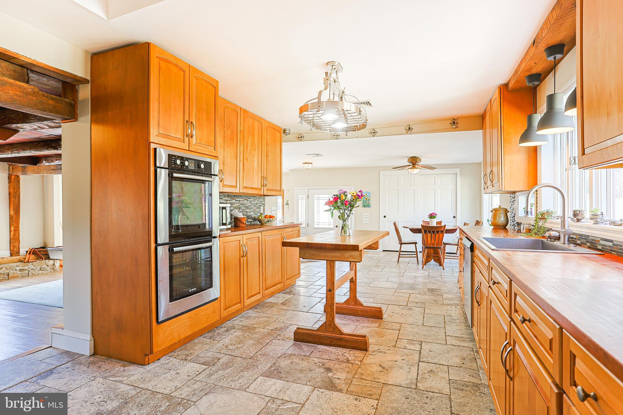38 Devyn Drive Chester Springs, PA 19425 - Photo 20 of 40 a kitchen with stainless steel appliances kitchen island granite countertop a table chairs in it and wooden floors
