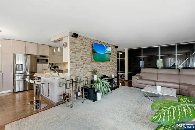 a kitchen with stainless steel appliances granite countertop a sink refrigerator and microwave