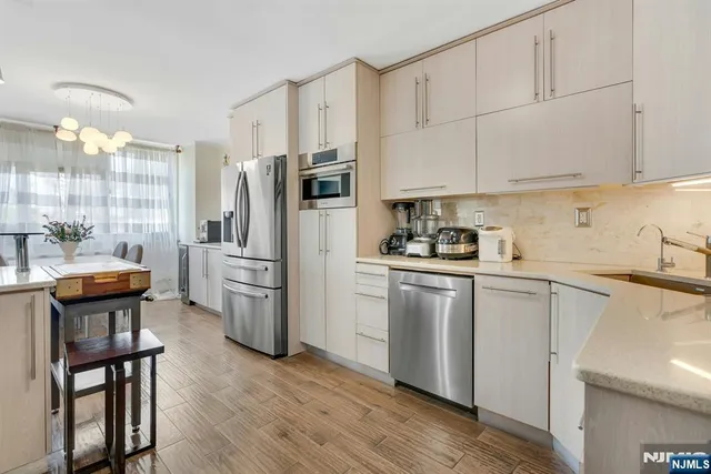 a kitchen with stainless steel appliances a sink cabinets and wooden floor
