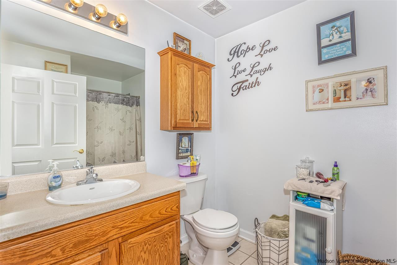 1129 Maggie Road Newburgh, NY 12550 - Photo 17 of 28 a bathroom with a granite countertop sink a toilet and a mirror