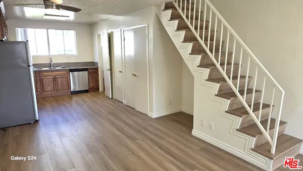 a view of a kitchen with wooden floor and electronic appliances