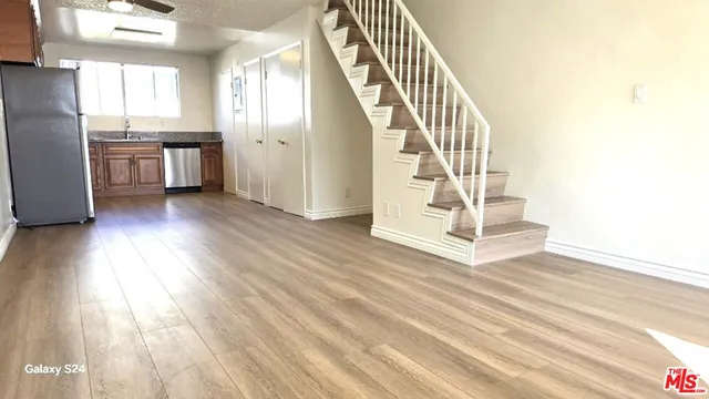 a view of entryway and kitchen with wooden floor