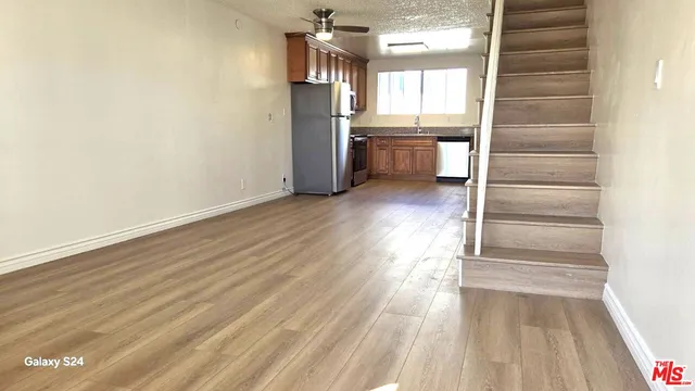 a kitchen with stainless steel appliances granite countertop a refrigerator a sink and a stove