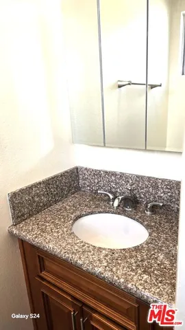a bathroom with a granite countertop toilet and a sink