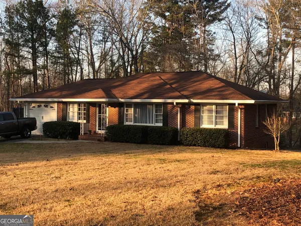 a front view of house with yard and trees around