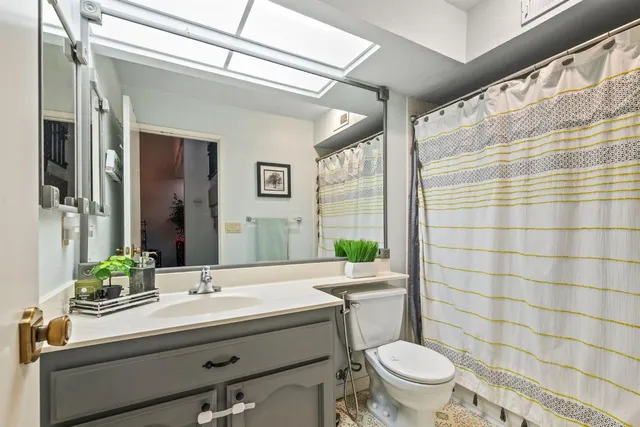 a bathroom with a sink a toilet a mirror and shower