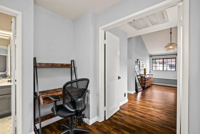 a view of a hallway with wooden floor and a livingroom