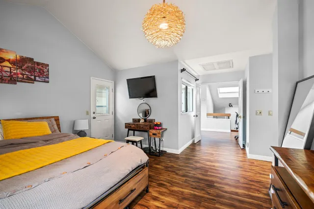 a bedroom with a bed and wooden floor