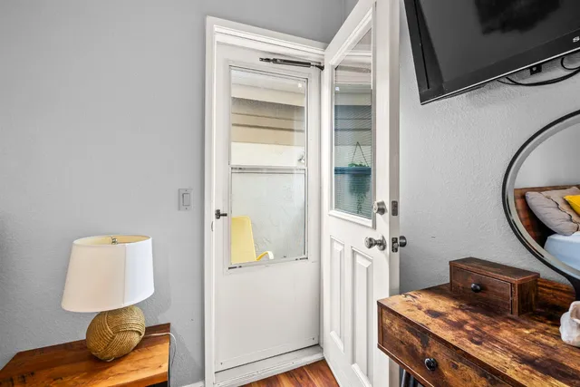 a bedroom with a bed and a lamp on dresser