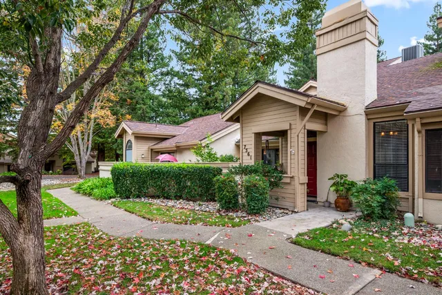 a front view of a house with a yard and potted plants