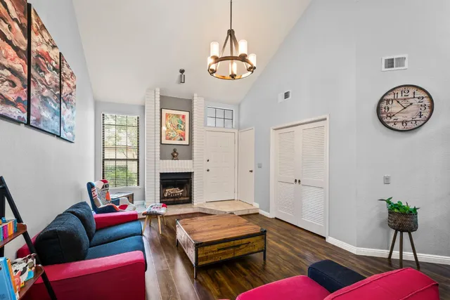 a living room with furniture a chandelier and a fireplace