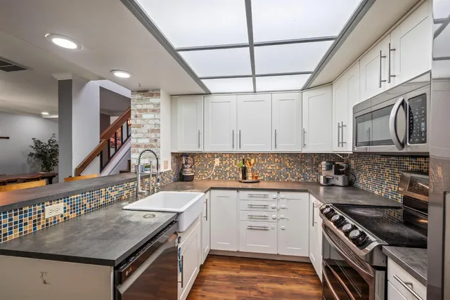 a kitchen with stainless steel appliances granite countertop a sink stove and cabinets