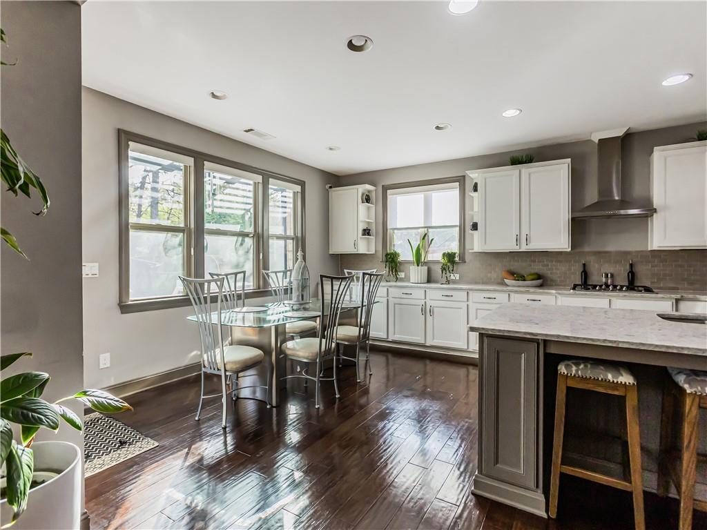 3820 Mabry Ridge Drive Buford, GA 30518 - Photo 7 of 55 a kitchen with stainless steel appliances granite countertop a stove top oven a sink a dining table and chairs with wooden floor