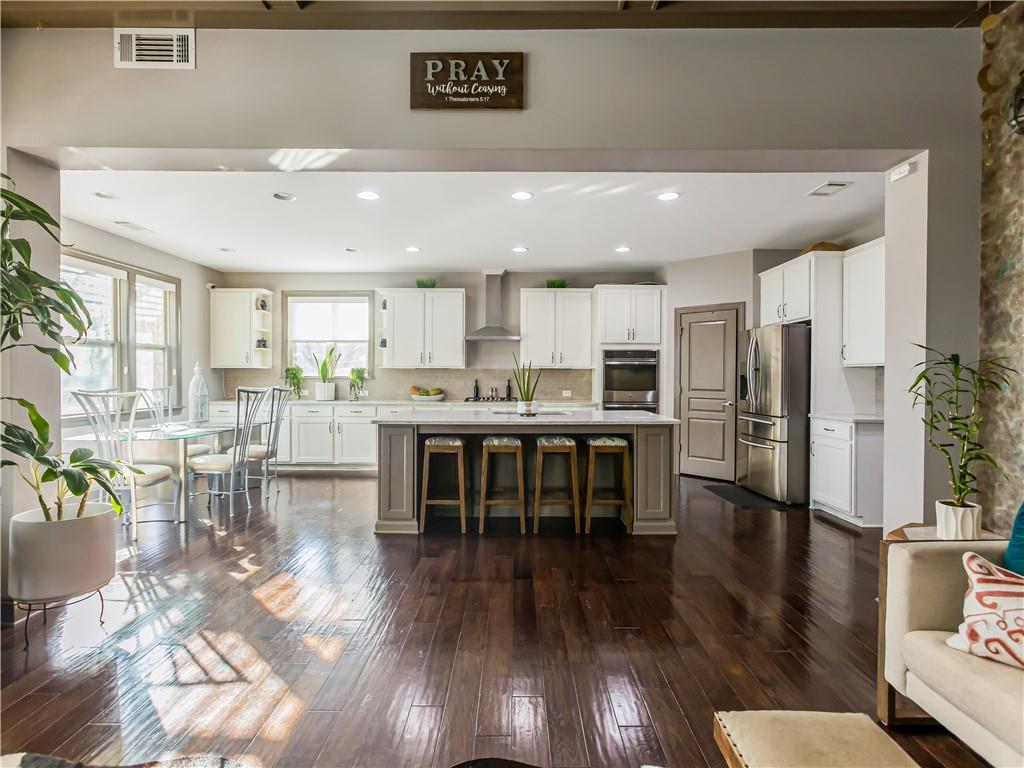 3820 Mabry Ridge Drive Buford, GA 30518 - Photo 8 of 55 a kitchen with stainless steel appliances kitchen island granite countertop a refrigerator a stove a sink a dining table and chairs with wooden floor