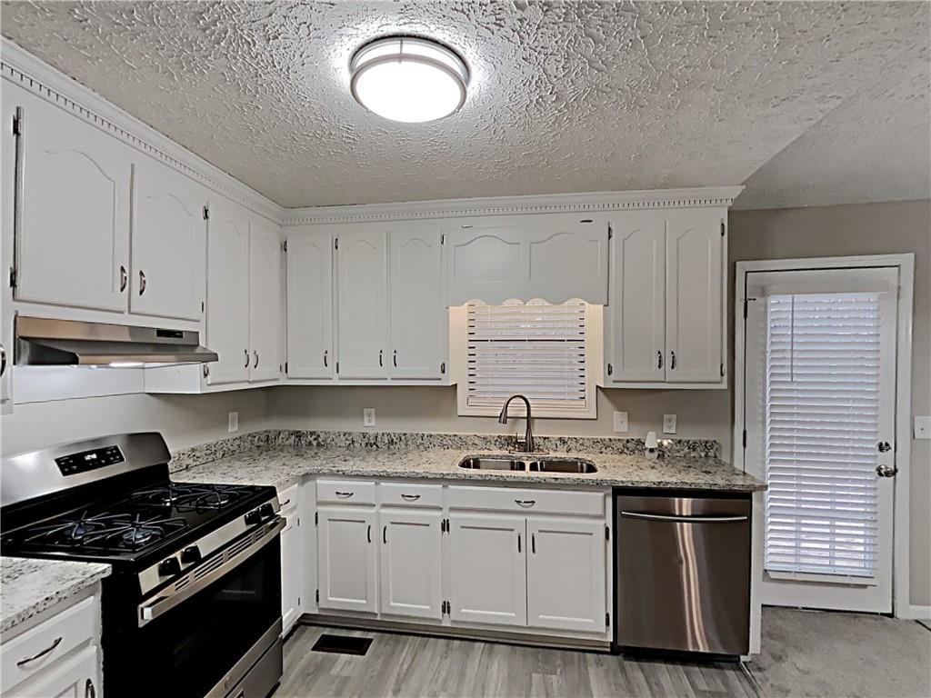 3548 Cherokee Overlook Drive Canton, GA 30115 - Photo 11 of 24 a kitchen with granite countertop a sink a stove and cabinets