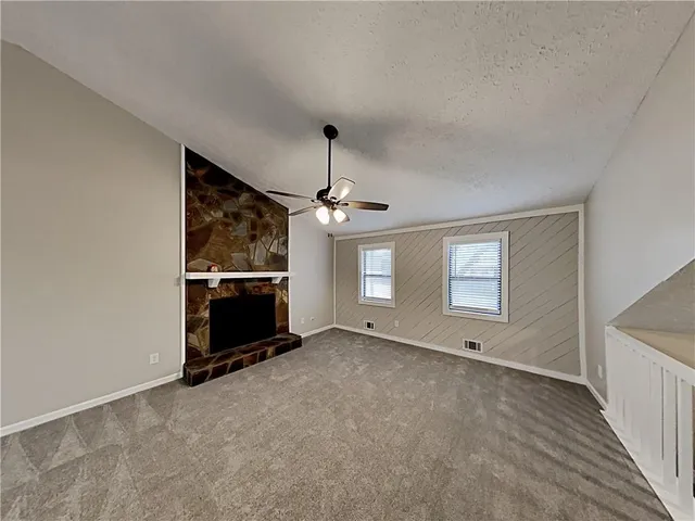 an empty room with windows and fireplace