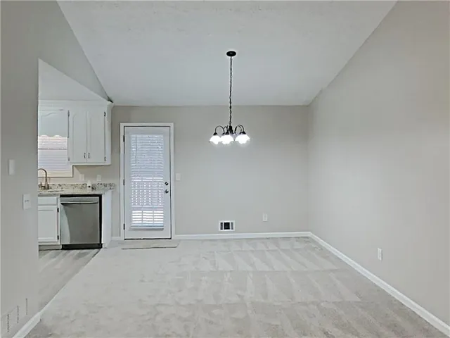 a view of a kitchen with granite countertop a stove top oven a sink and dishwasher
