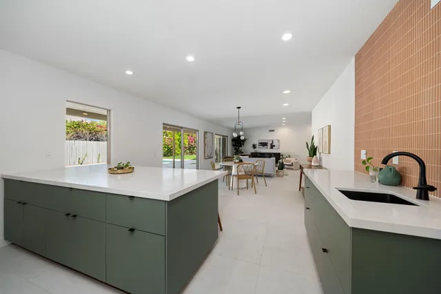 a kitchen with a sink a counter appliances and cabinets