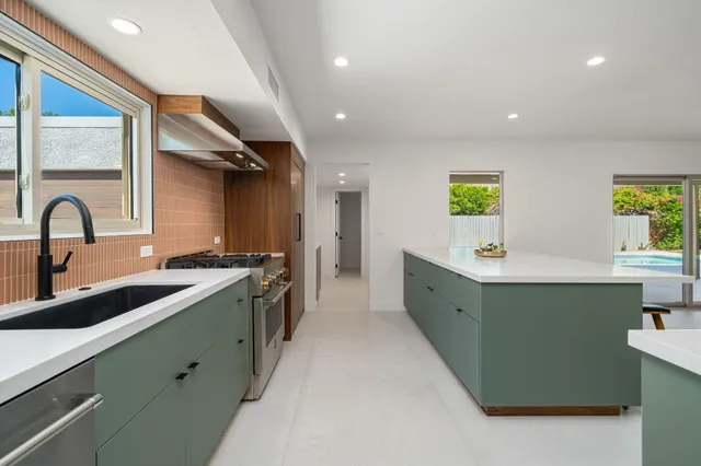 a large kitchen with kitchen island a sink stainless steel appliances and cabinets