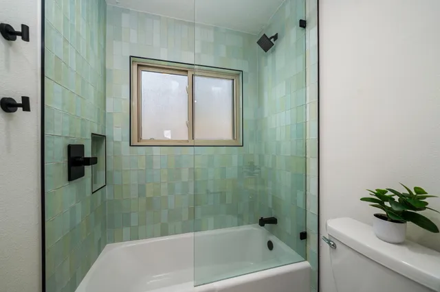 a bathroom with a bathtub a shower and a sink